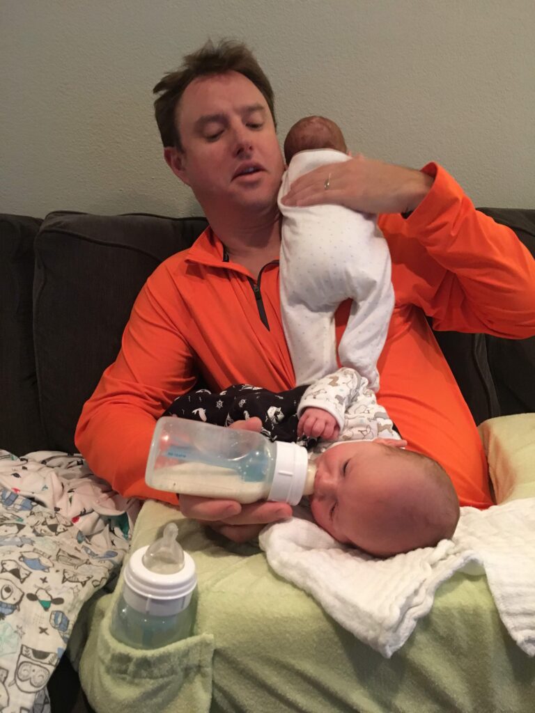 Dad feeding twin boys