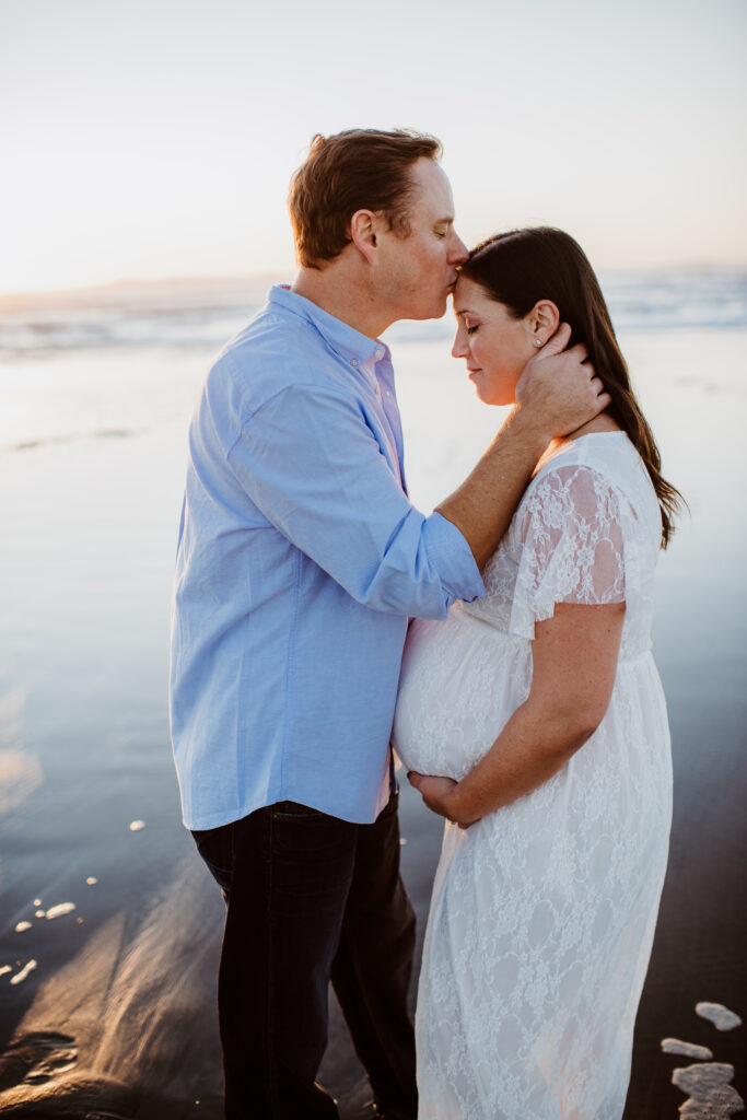 Husband kissing pregnant wife on forehead 