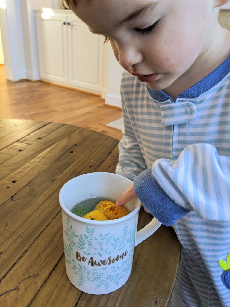 Toddler pointing at lemon water 