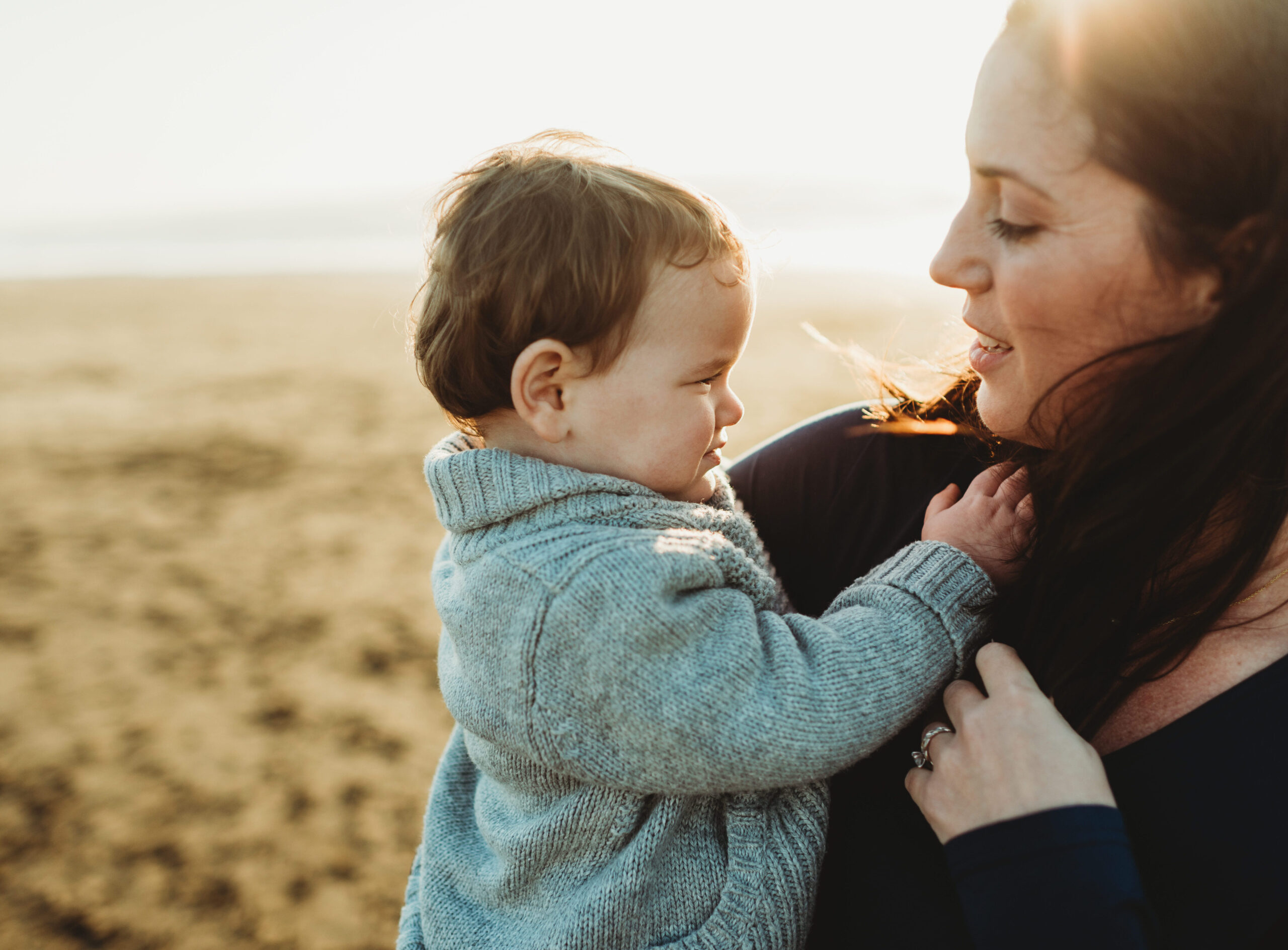 Mom holding son on the beach and looking lovingly into each other's eyes